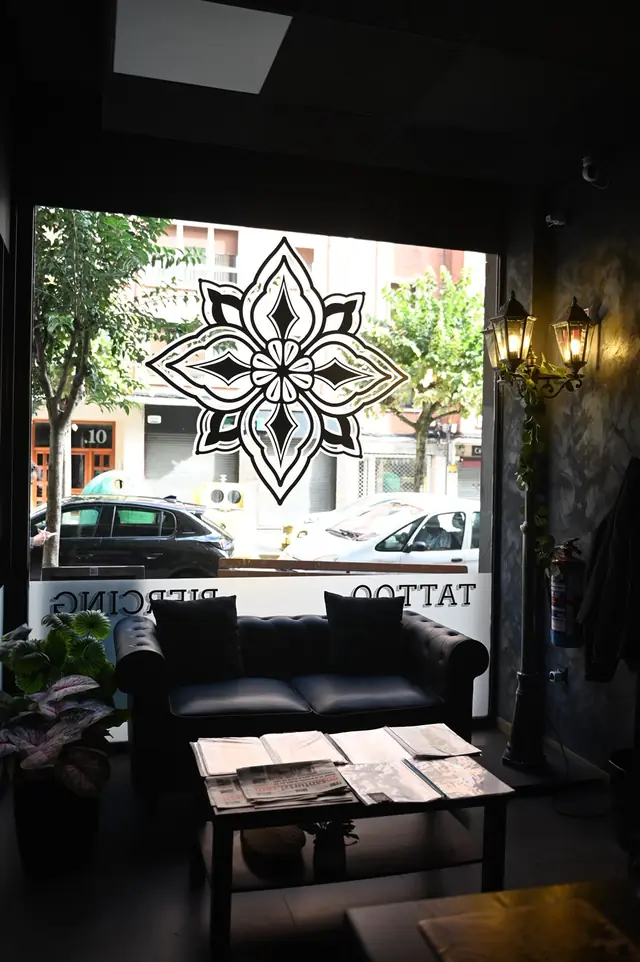 Sala de espera con sofá Chesterfield y el logo en el escaparate