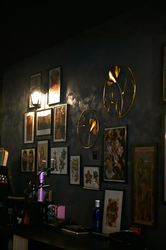 Pared con láminas de tatuaje y adornos dorados