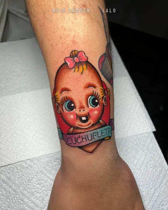 Muñeca kewpie con cinta «Cuchufleta» en la muñeca