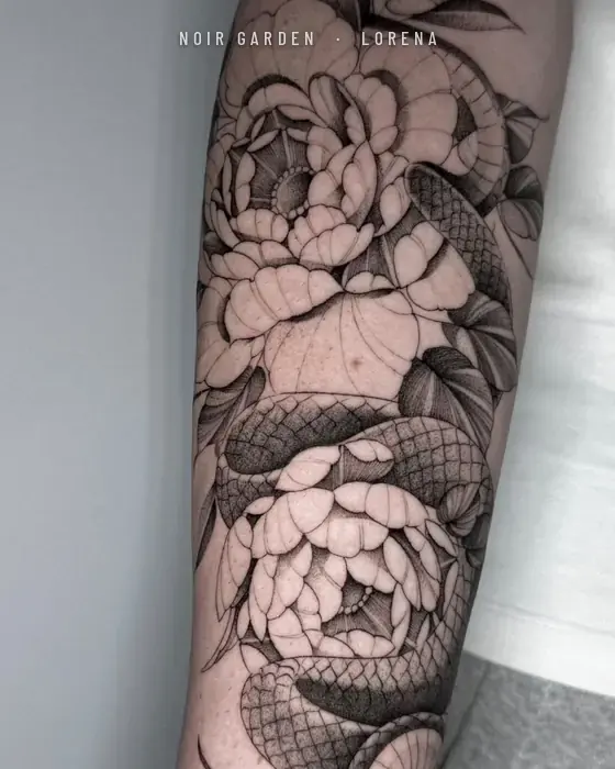 Serpiente entre peonías en el antebrazo