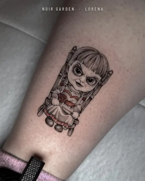 Muñeca sentada en una silla con detalles en rojo