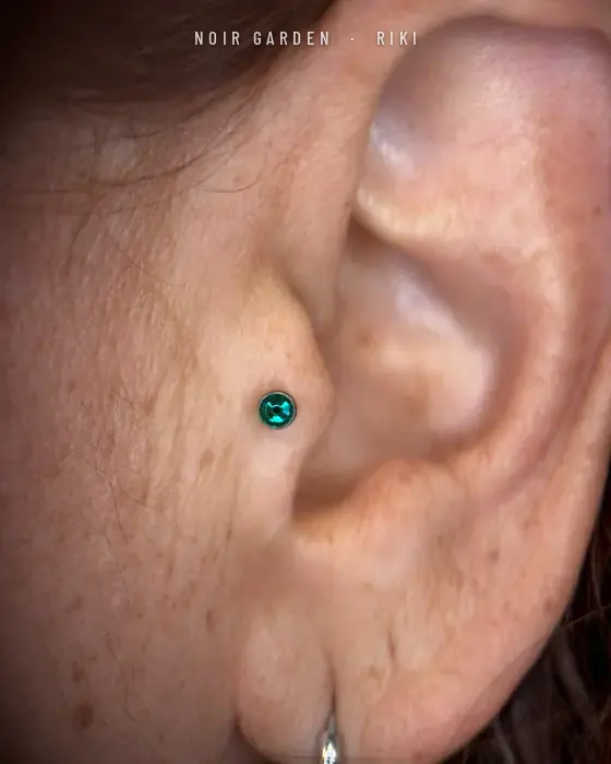 Piercing de tragus con piedra verde